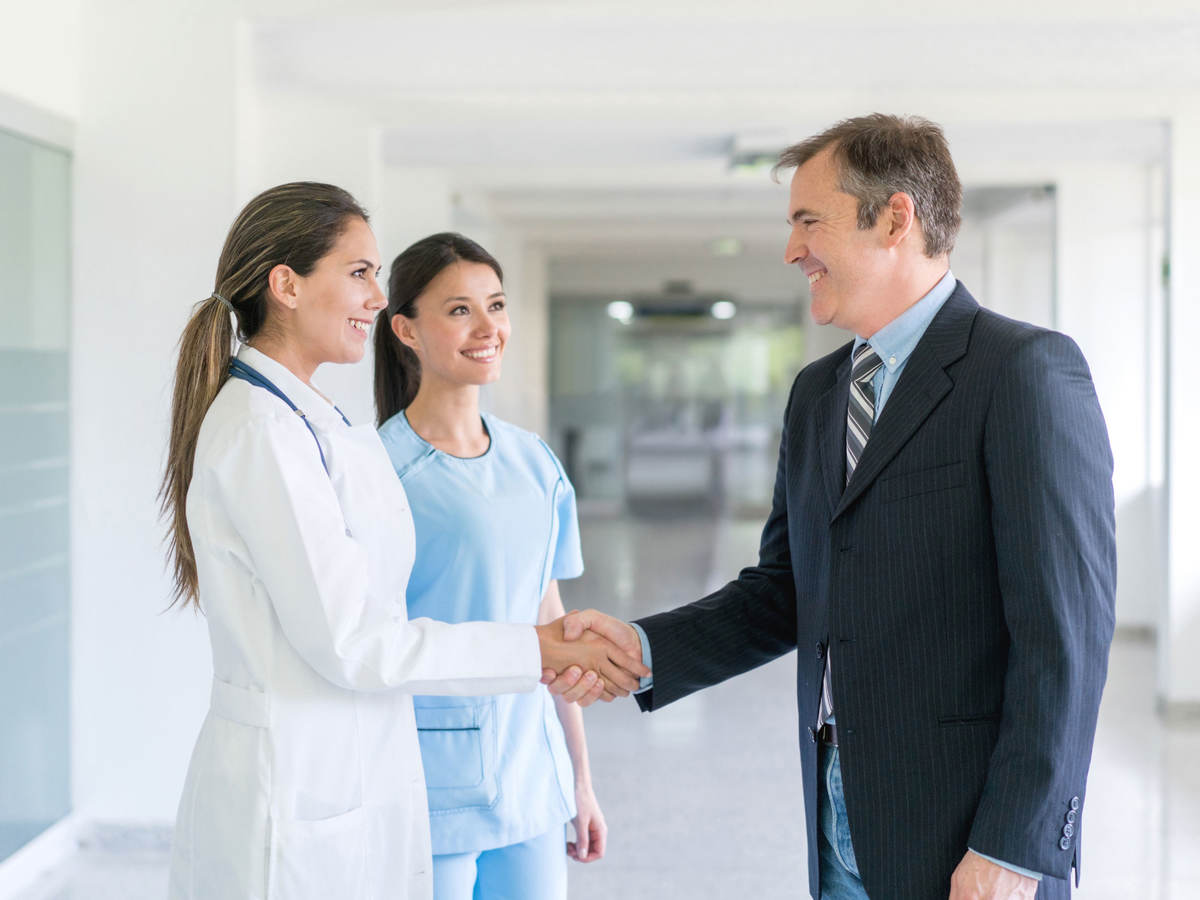 Doctor shaking a person's hand inside a hospital