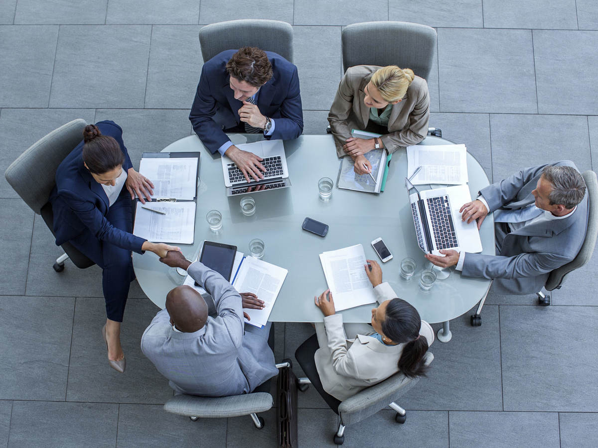 Overhead view of business people sitting around a conference table while working