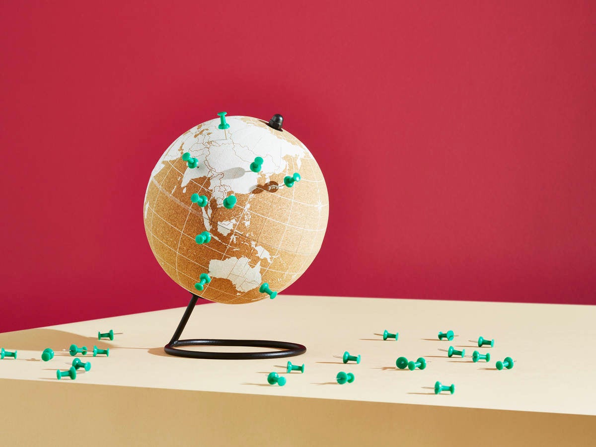 Globe with push pins indicating certain countries.