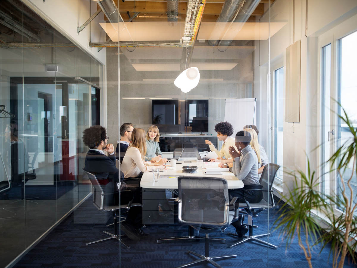 A board meeting inside a glass conference room