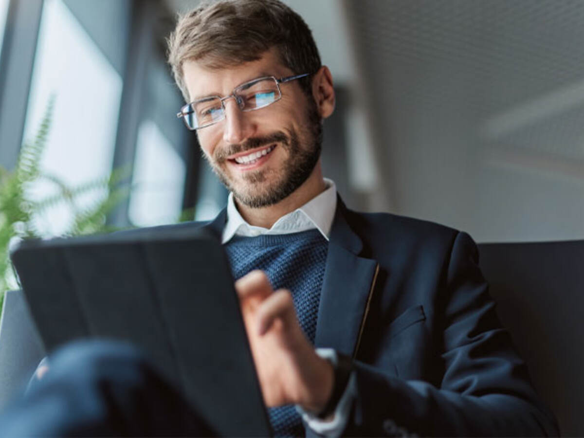 Business professional sitting on a couch while using a tablet