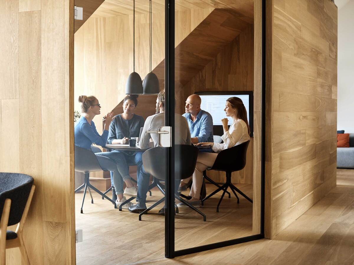 Business executives meeting inside a modern wood paneled conference room