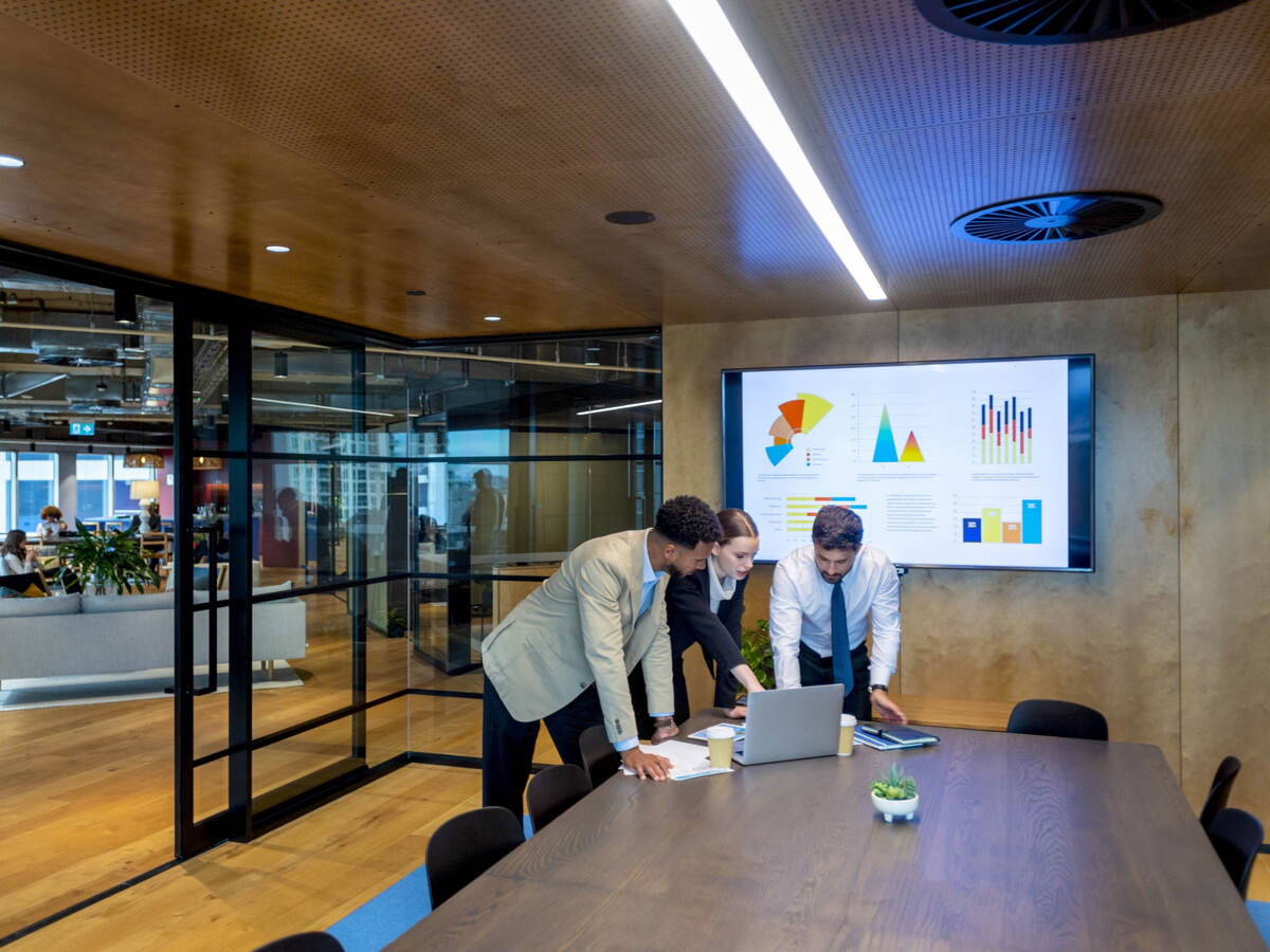 Three business colleagues reviewing metrics in a meeting