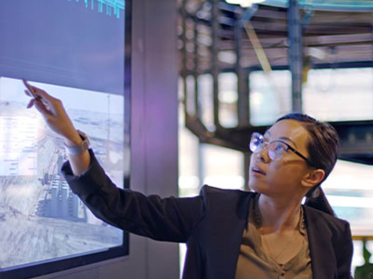 Person pointing at a graph on a large tv screen