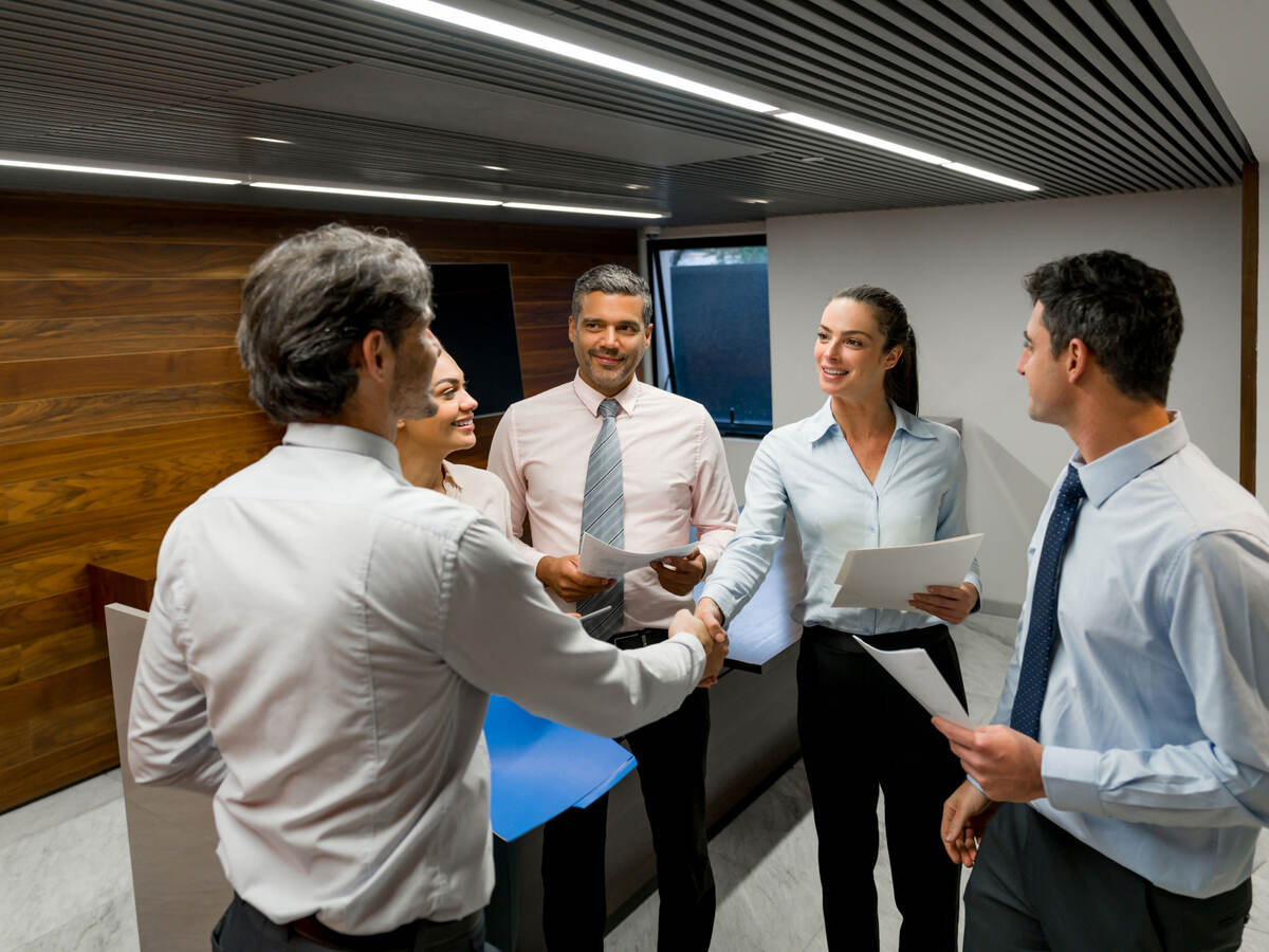 A group of business professionals greeting each other before a meeting