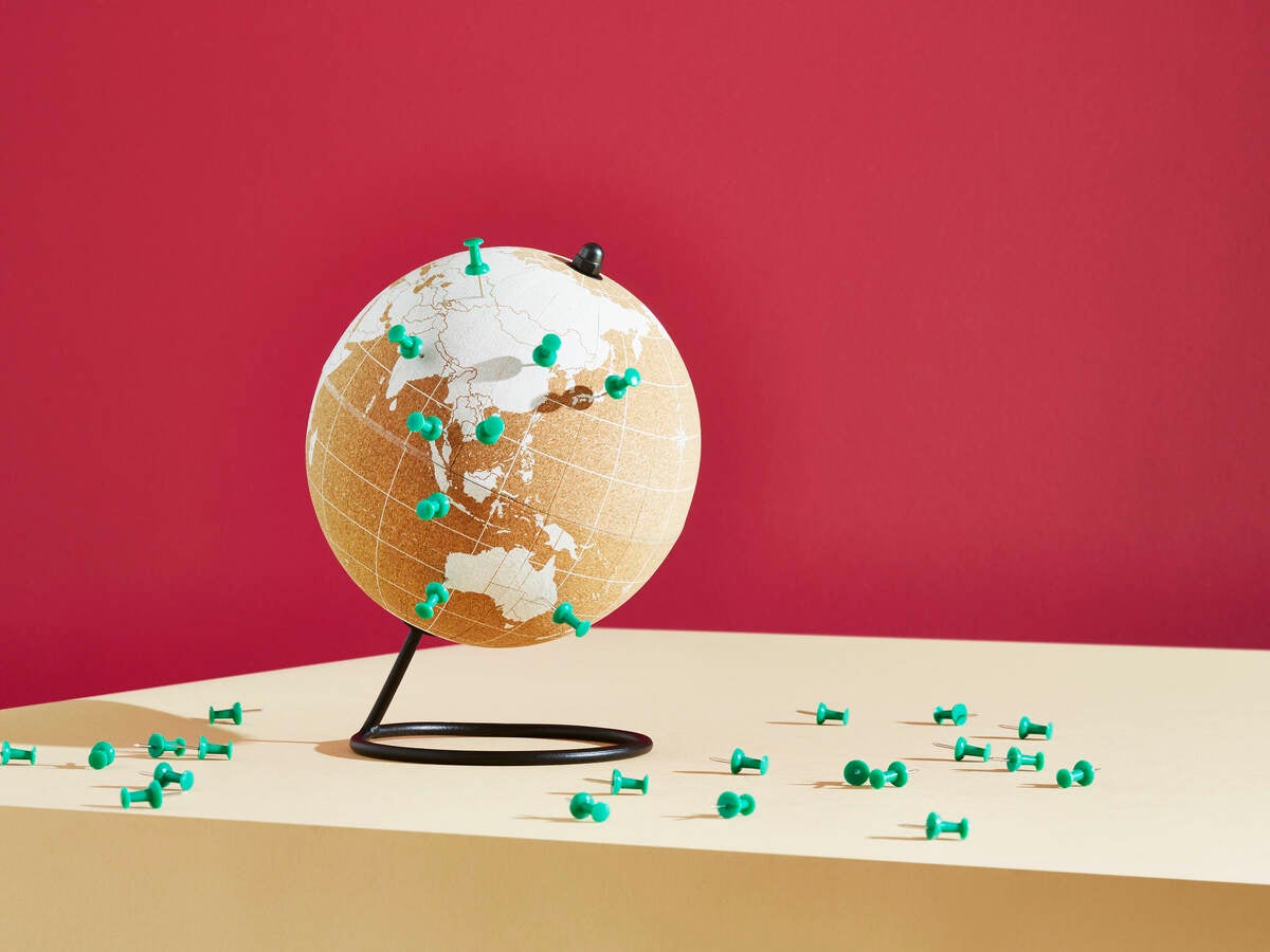World map on globe with push pins for locations