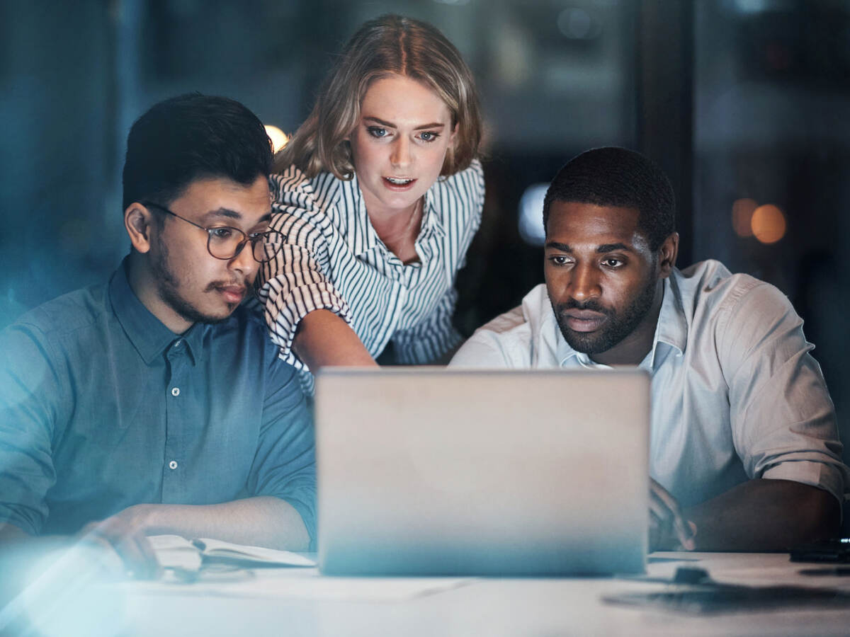 Group of colleagues collaborating in front of a laptop