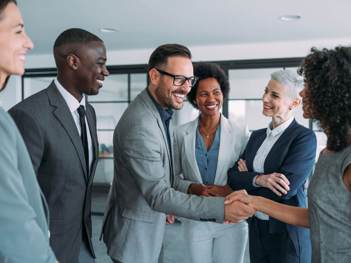 Group of business professionals greeting each other and shaking hands 