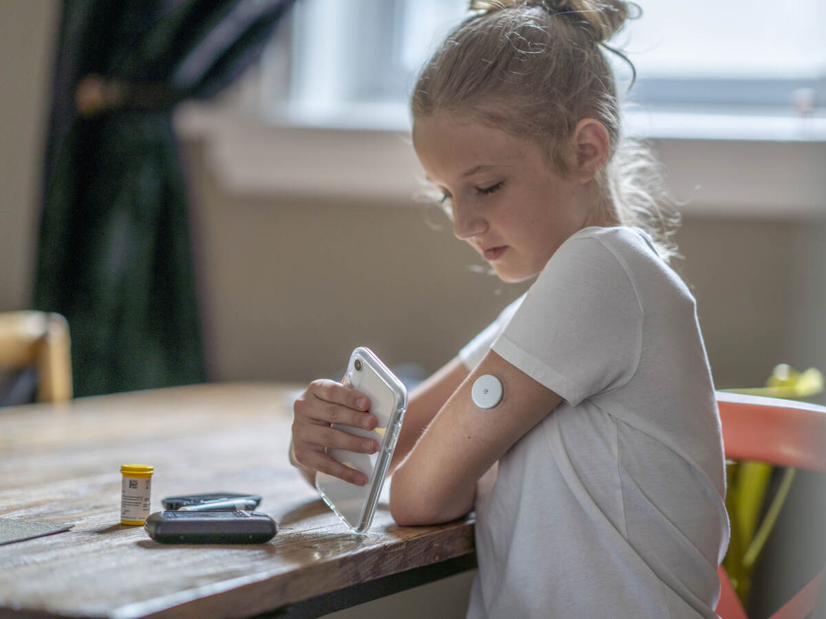 Young person testing their blood sugar with their mobile phone.
