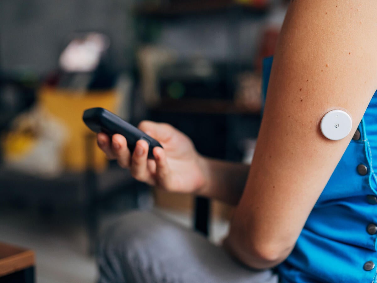 Person testing their blood sugar with wireless medical device