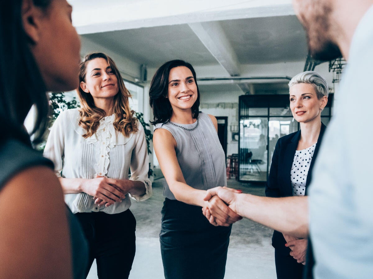 Group of business professionals greeting each other and shaking hands 