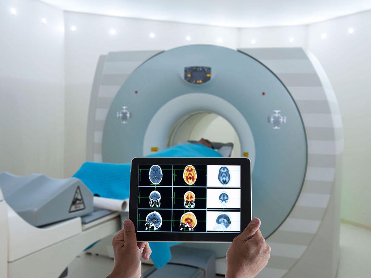 Medical professional reviewing CT scans on a tablet