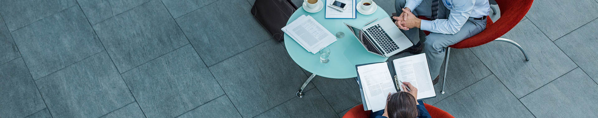 Distant shot of three coworkers sitting at a table