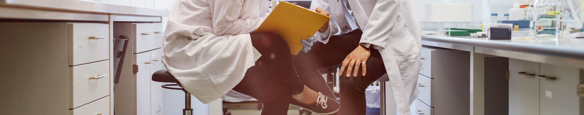 Two lab techs discussing paperwork