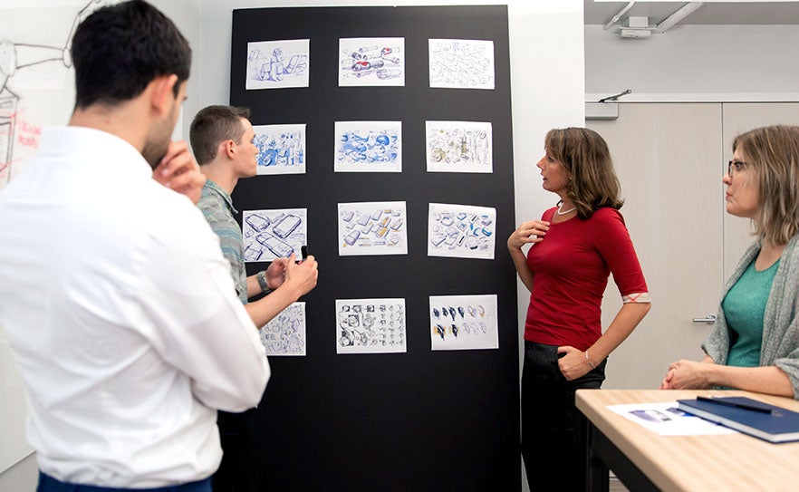People reviewing plans on a wall