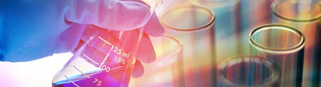 Person looking at blue liquid in an Erlenmeyer flask
