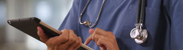 Doctor doing work on a tablet.