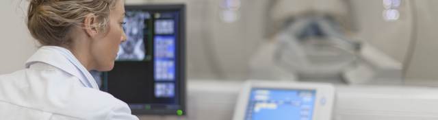 Medical professional using electronic controls to test a medical scanning device.