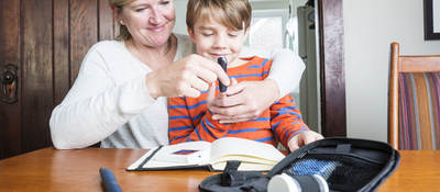 Mother helping son use medical device