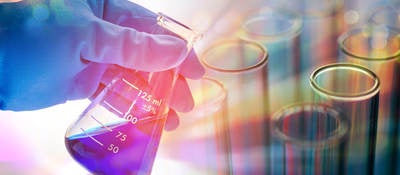 Person looking at blue liquid in an Erlenmeyer flask