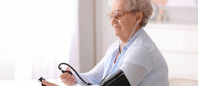 Elderly person measuring their blood pressure