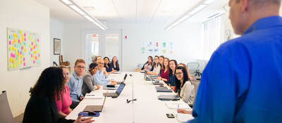 Person presenting to a conference room full of people