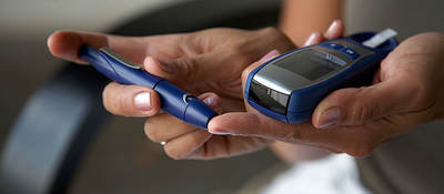 Person using a machine to check their blood sugar