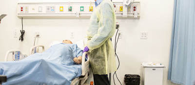 Doctor standing over patient in a hospital