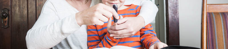 Mother helping son use medical device