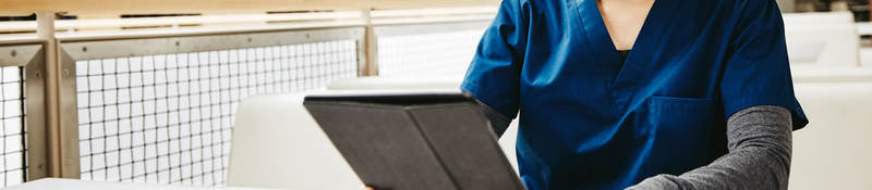 Medical student reading tablet in a library