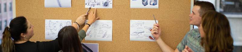 Going over designs on a bulletin board.