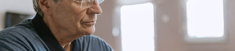Senior man using blood pressure cuff in his home
