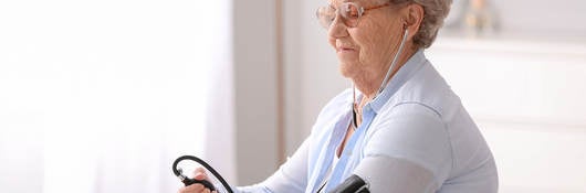 Elderly woman measuring her blood pressure