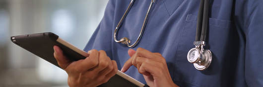 Doctor doing work on a tablet.