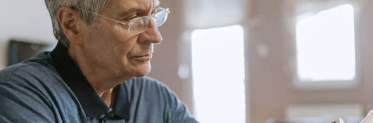 Senior man using blood pressure cuff in his home