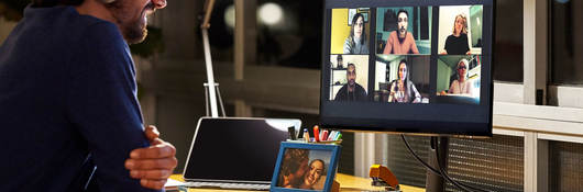 Person attending a virtual meeting at their desk at night
