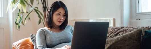 A person sitting on couch using their laptop