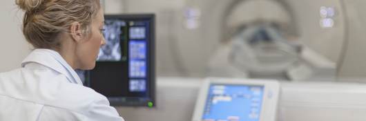 Medical professional using electronic controls to test a medical scanning device.