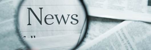 Magnifying glass focused the word news.