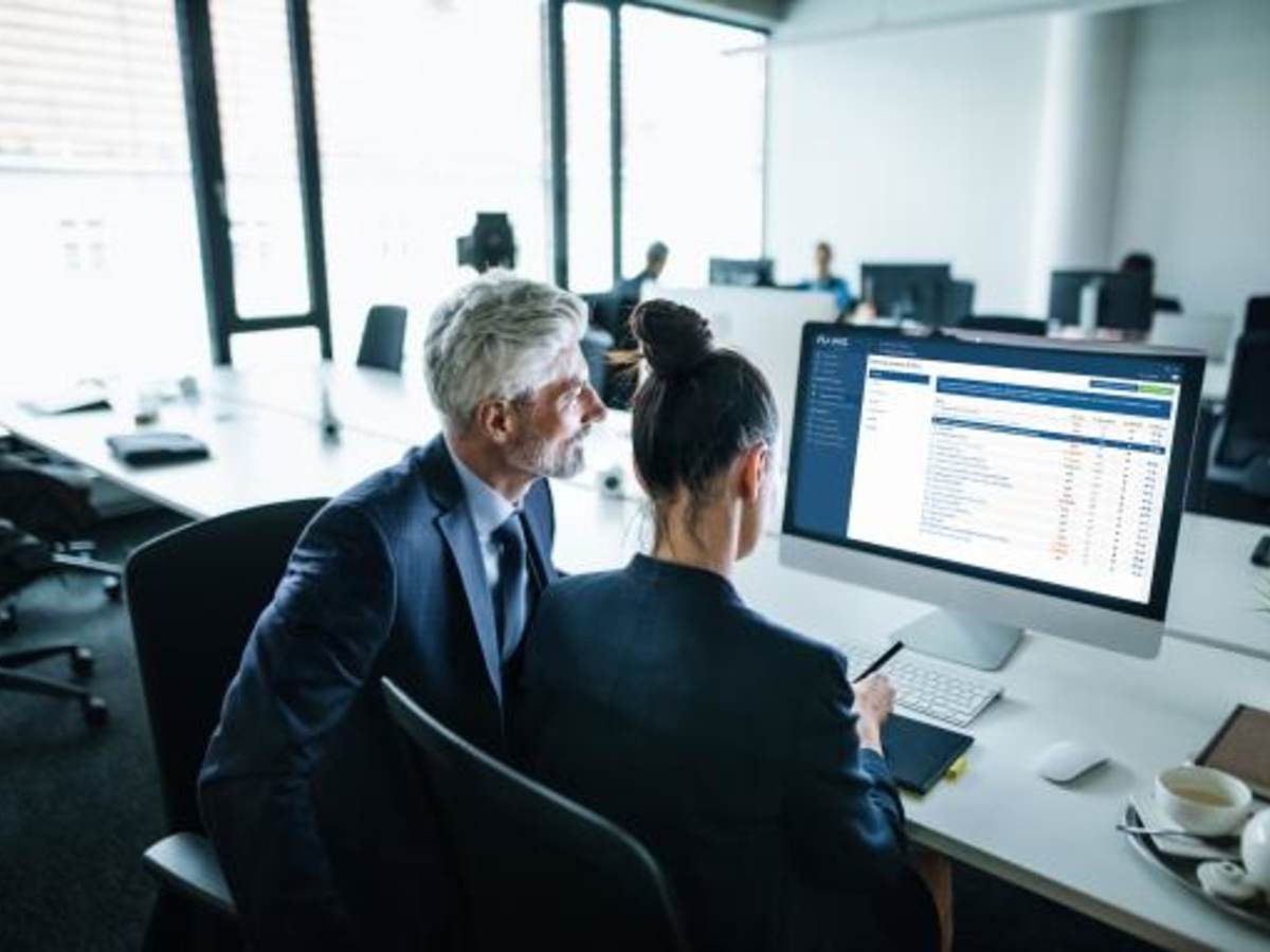 2 people at a desk looking at a monitor with Smart Builder