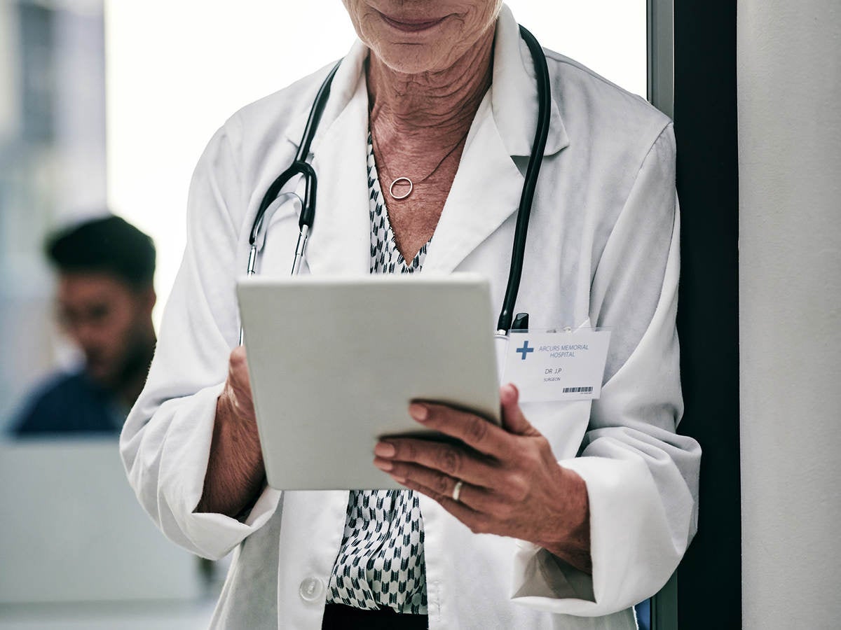 Doctor looking at a tablet screen.