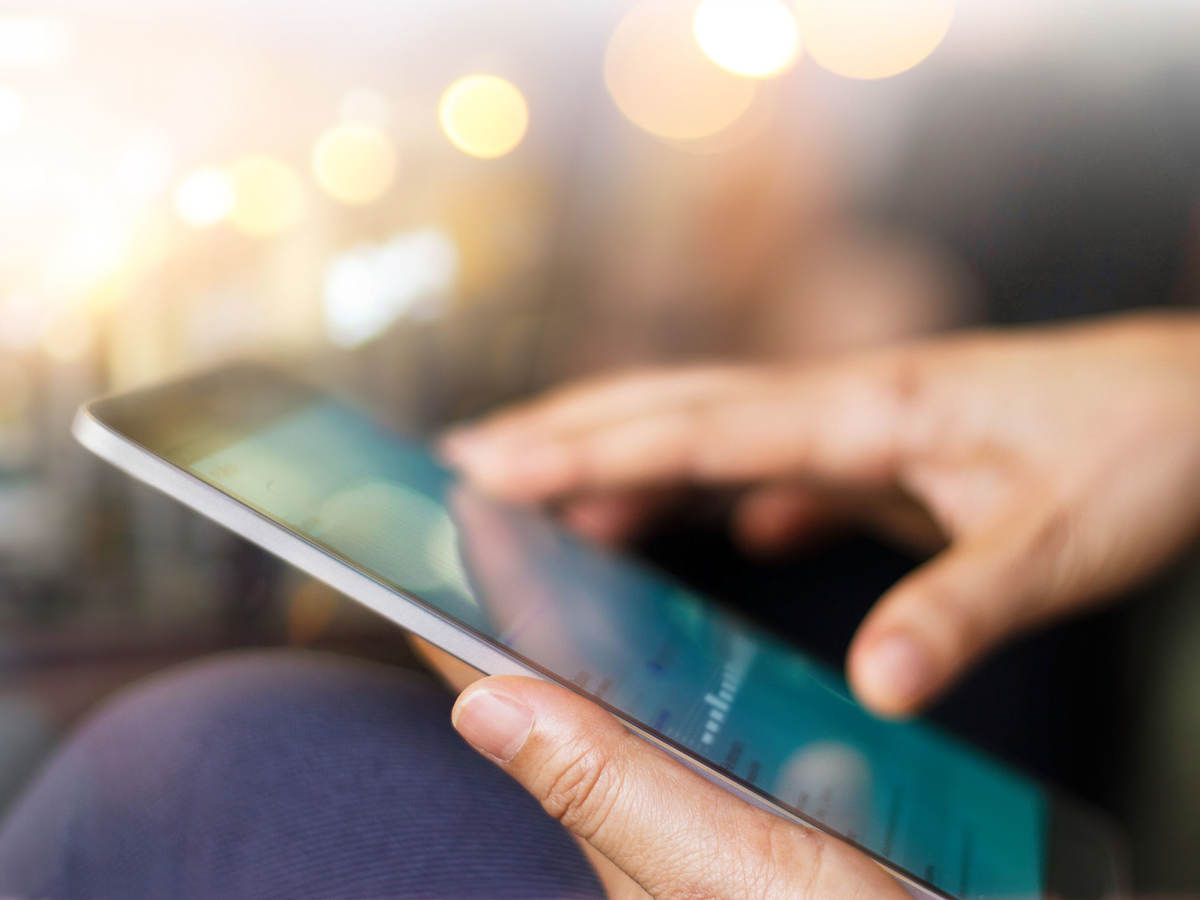 Close up of a person sitting and reading a tablet
