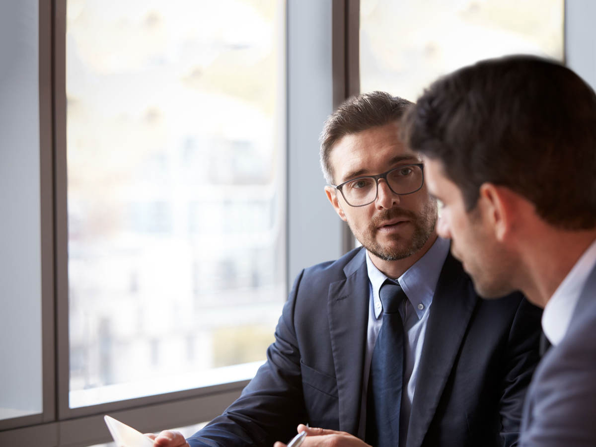 2 consultants talking at a table.