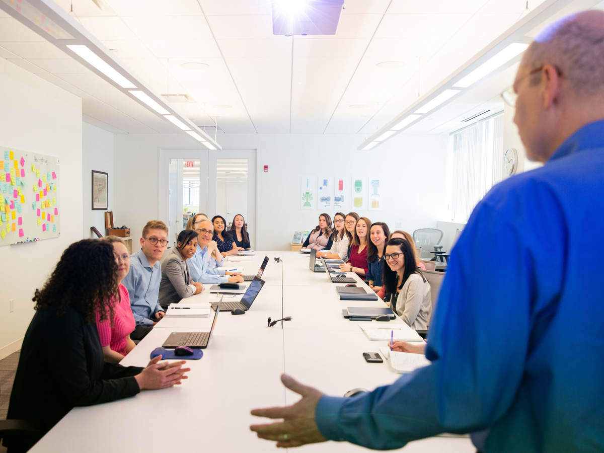 Person presenting to a conference room full of people