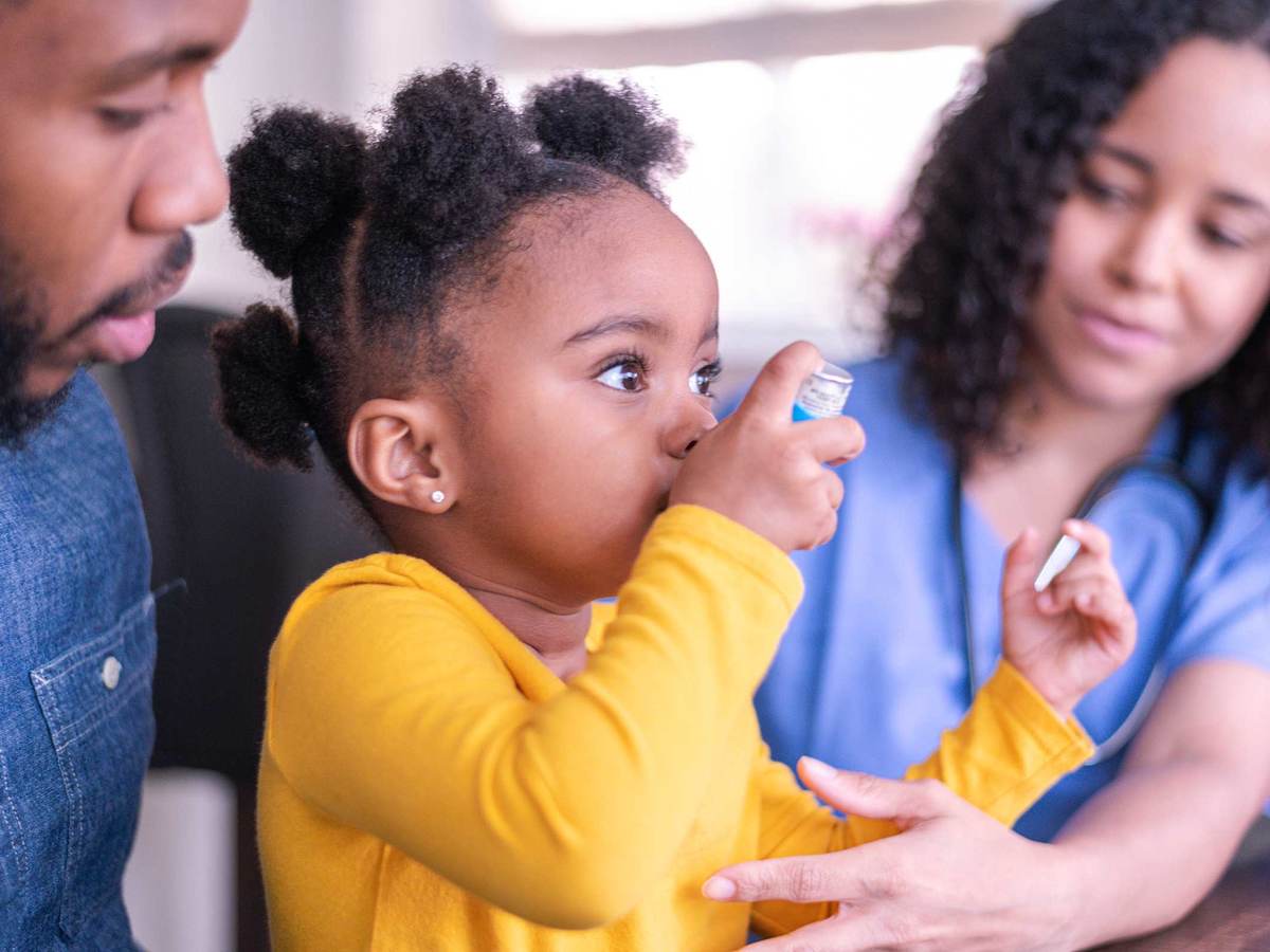 Child using an inhaler with the help of a doctor