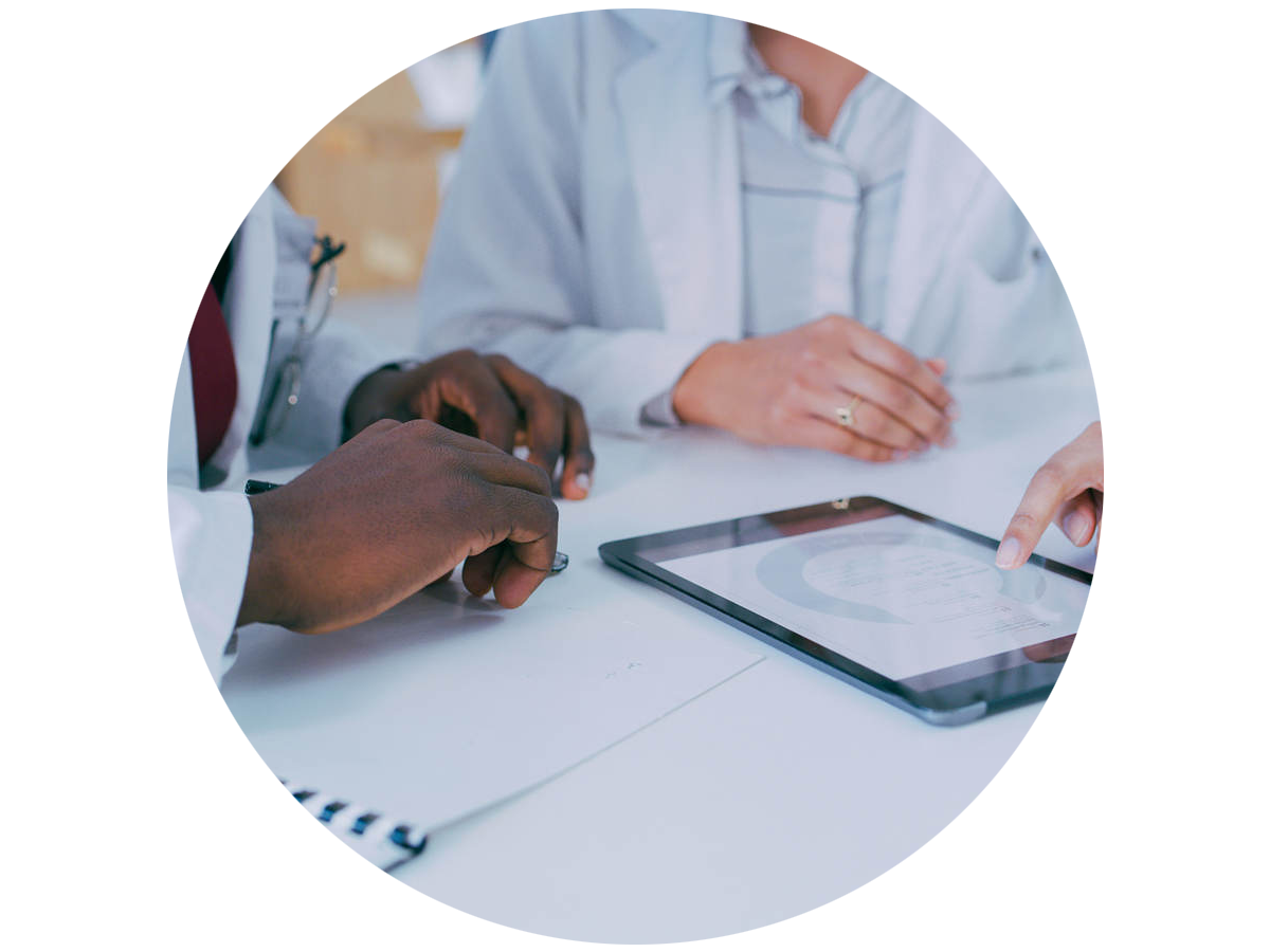 Two doctors reviewing a tablet while seated at a table